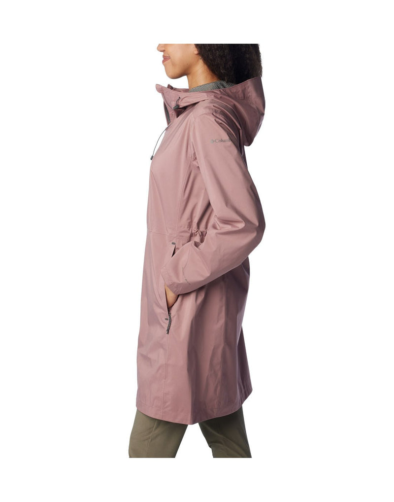 Woman wearing Columbia Women's Weekend Adventure™ Long Shell Jacket in fig, zipped up, side view with hands in pockets