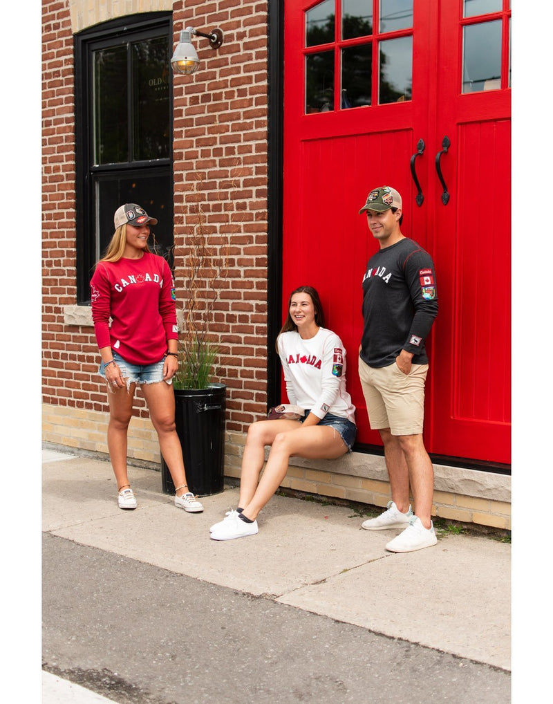Boy wearing canada men's crested long sleeve shirt and standing with two girls