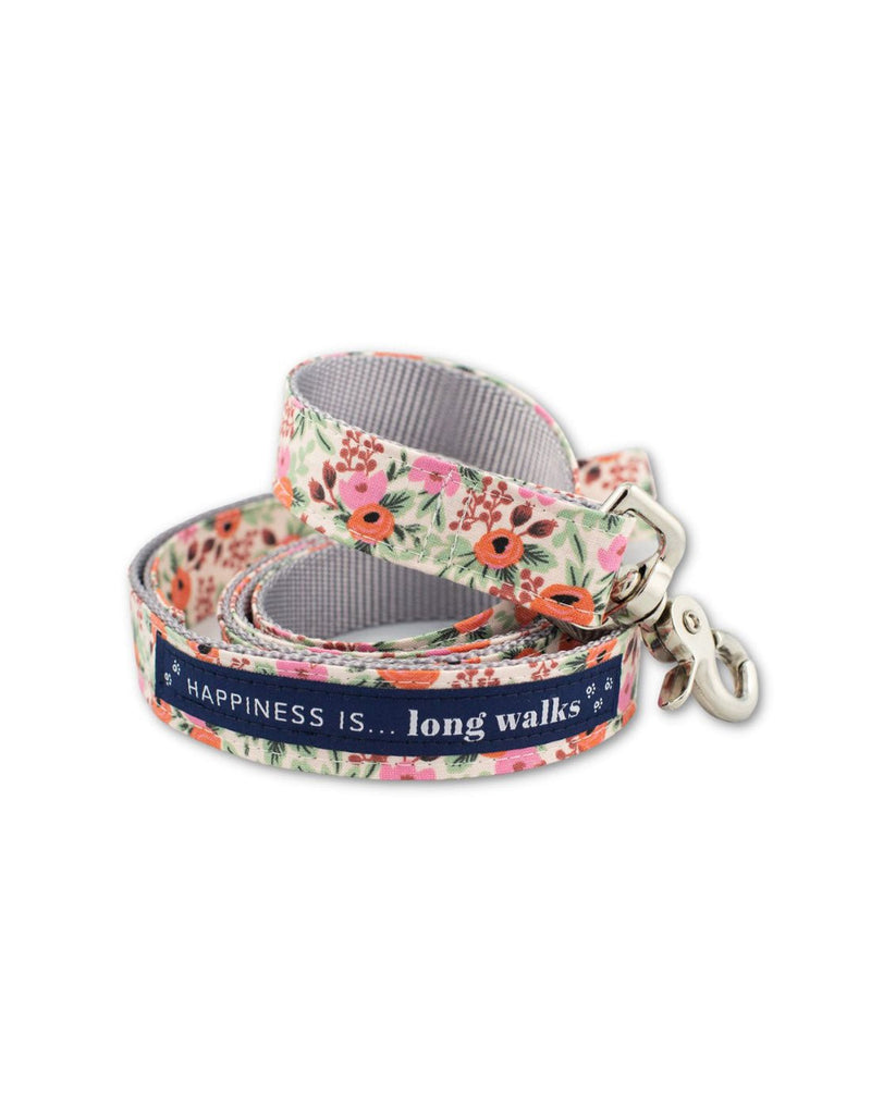 Happiness Is... Long Walks Floral Dog Leash coiled up, with silver clip and navy blue strip with white small paw prints and words that read Happiness Is...long walks 