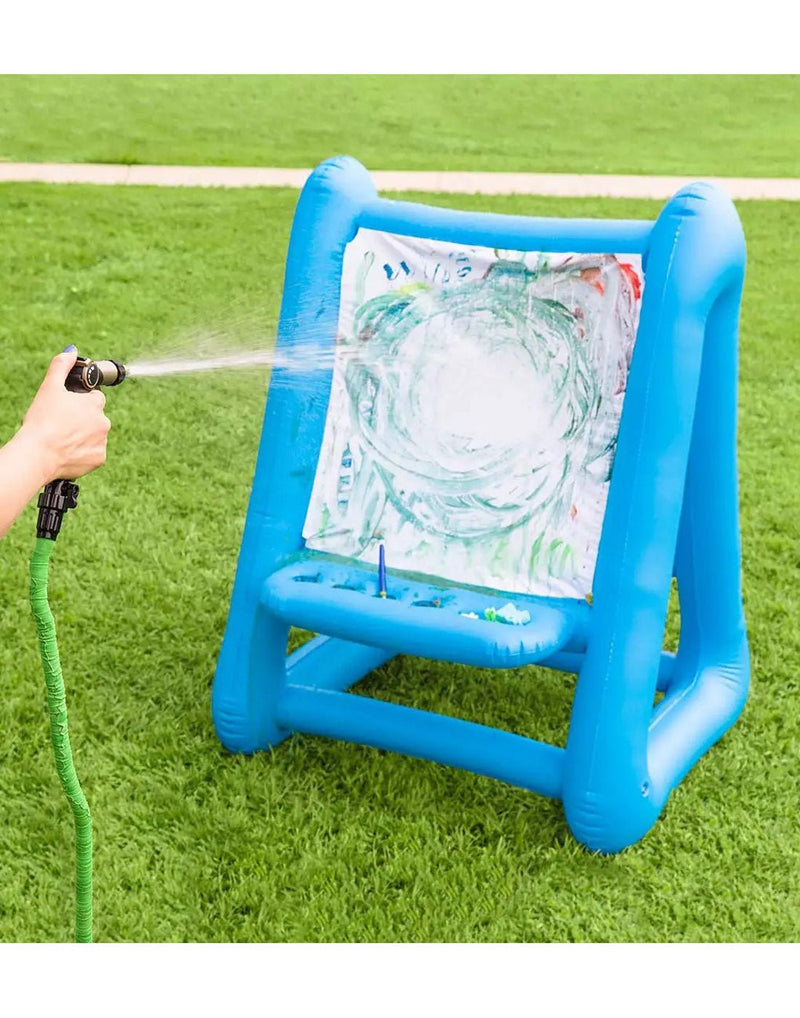 Hearth Song Double-Sided Inflatable Easel being hosed clean with garden hose on the grass