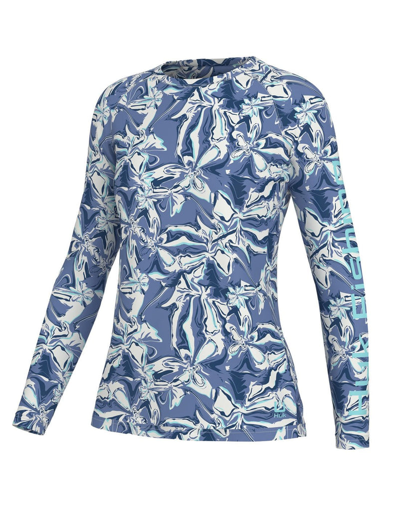 Huk Women's Brackish Flow Pursuit Long Sleeve, front view in crystal blue with white, blue, light blue and turquoise swirl pattern and Huk Fishing written in light blue down length of left sleeve