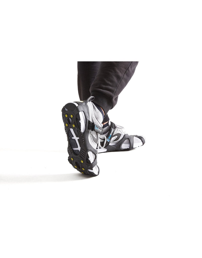 Icetrax V3 tungsten ice cleats with velcro straps on white shoes corner view
