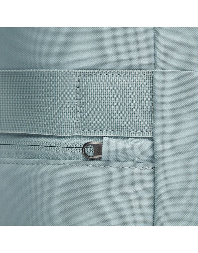 Close up of back zipper pull on fresh mint backpack, tucked into safety slot