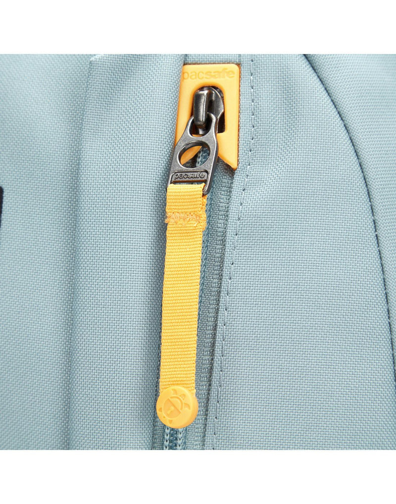 Close up of yellow zipper pull in dock lock on fresh mint backpack