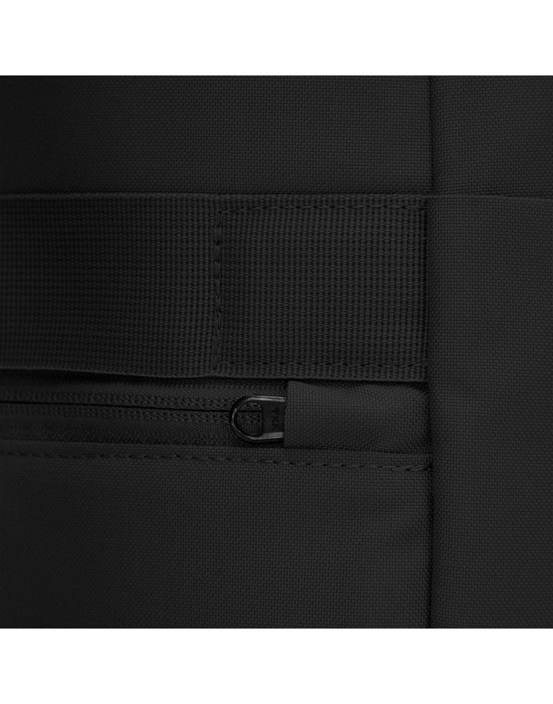 Close up of back zipper pull on jet black backpack, tucked into safety slot