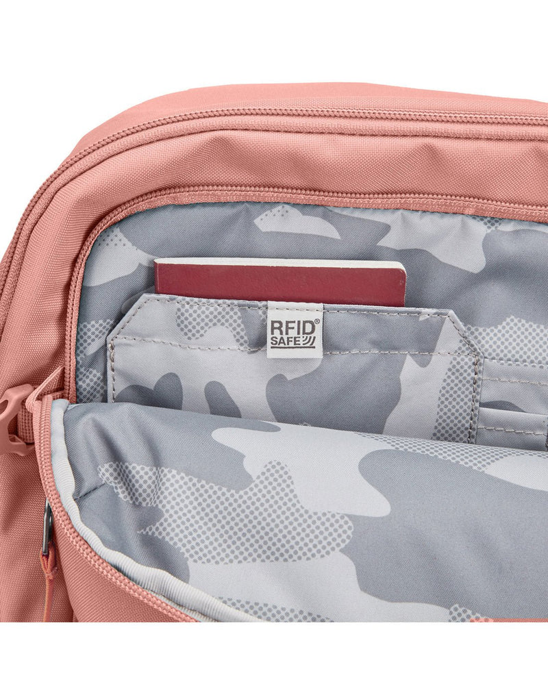 Pacsafe® Go 34L Anti-theft Carry-on Backpack in rose colour.  Close-up view of un-zipped RFID blocking pocket.