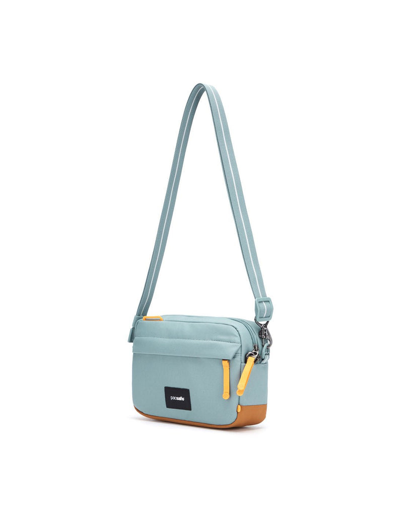 Pacsafe® GO Anti-Theft Crossbody Bag in fresh mint colour side view with Carrysafe® slashguard strap extended.