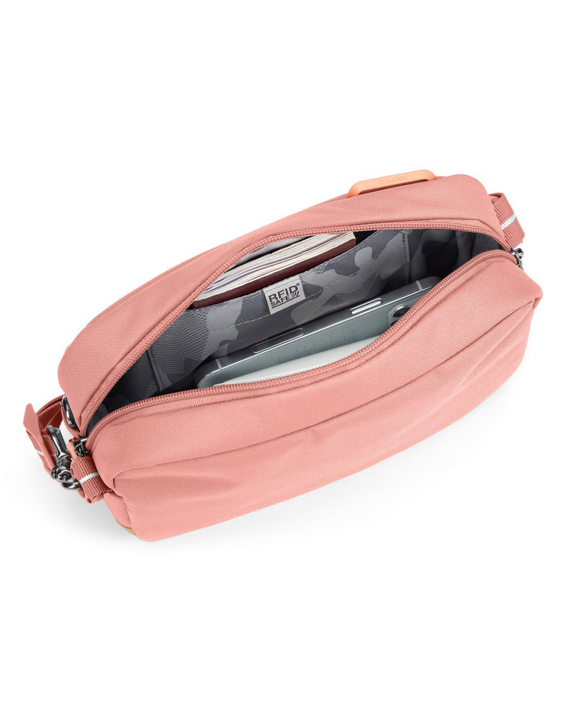 Pacsafe® GO Anti-Theft Crossbody Bag in rose colour showing interior with a RFID blocking pocket.