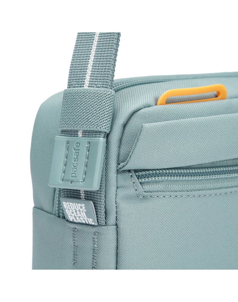 Pacsafe® GO Anti-Theft Crossbody Bag in fresh mint colour close-up of cut resistant shoulder strap and view of external attachment point for small items.