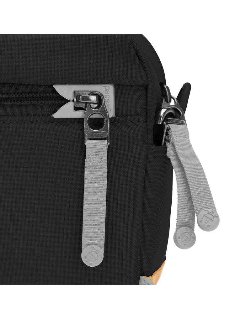 Pacsafe® GO Anti-Theft Crossbody Bag in jet black colour close up of two zipper tabs secured to a clip and one zipper secured with a dock lock.