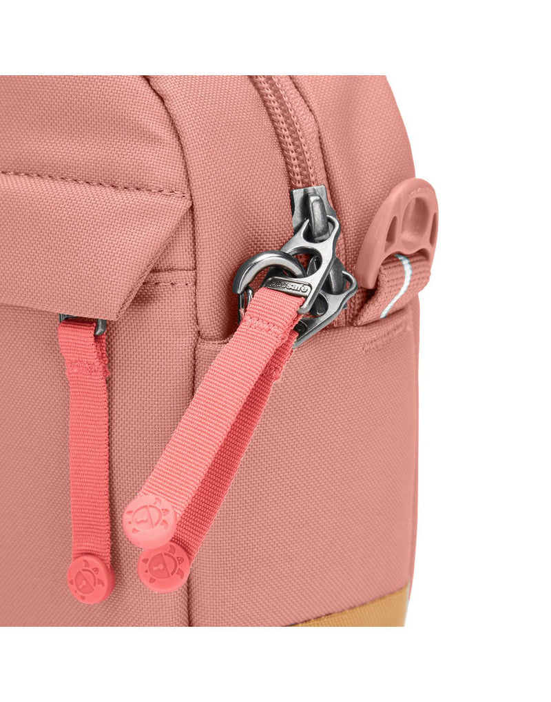 Pacsafe® GO Anti-Theft Crossbody Bag in rose colour close up of zipper tabs secured to a clip.