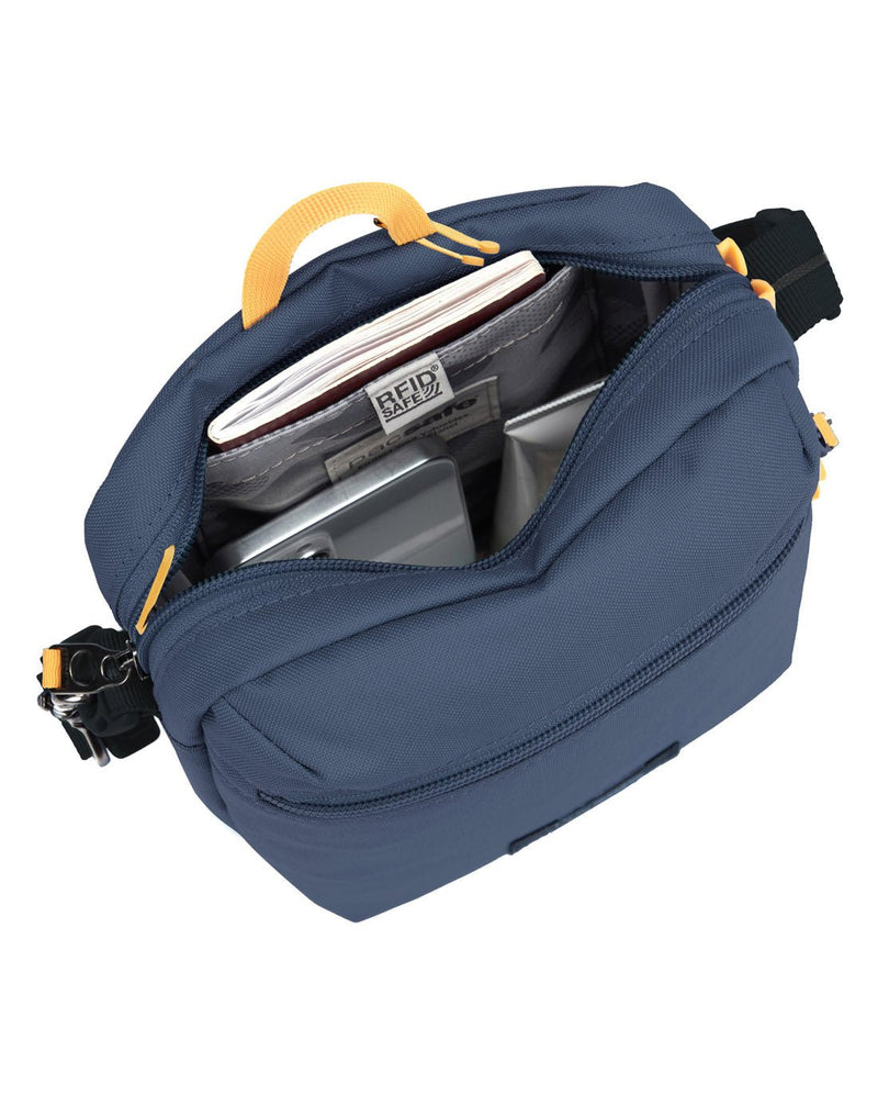 Pacsafe® GO Anti-Theft Festival Crossbody in coastal blue colour, top view with zipper open showing bag interior and RFID blocking pocket.