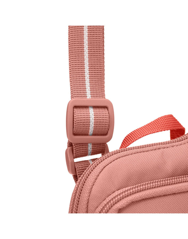 Pacsafe® GO Anti-Theft Tech Crossbody in rose colour close up of slashguard strap  and where it attached to the bag.