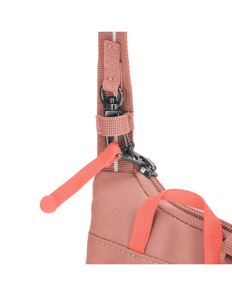 Pacsafe® GO Anti-Theft Tech Crossbody in rose colour close up of zipper tab secured using  zip clip.