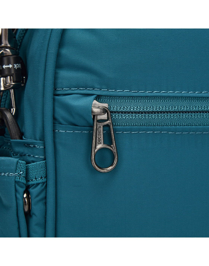 Close up of zipper pull tucked into security slot on tidal teal bag