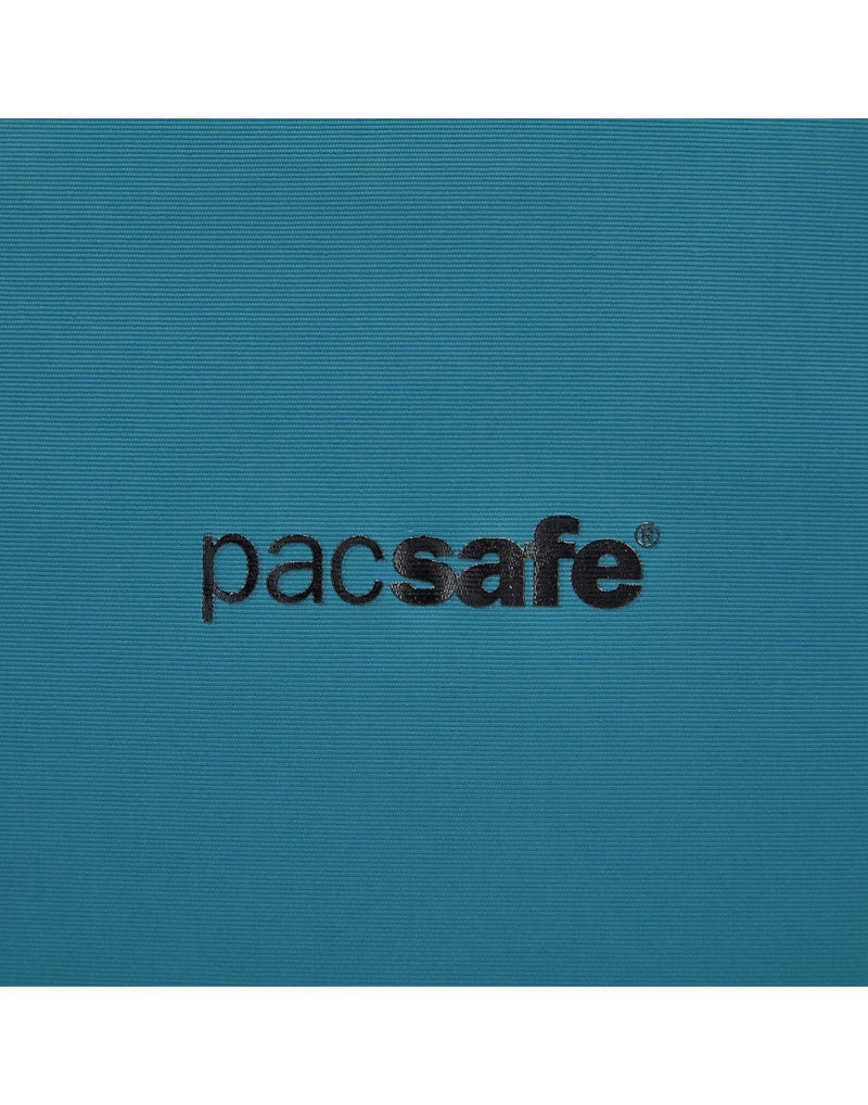 Close up of black Pacsafe logo on tidal teal backpack