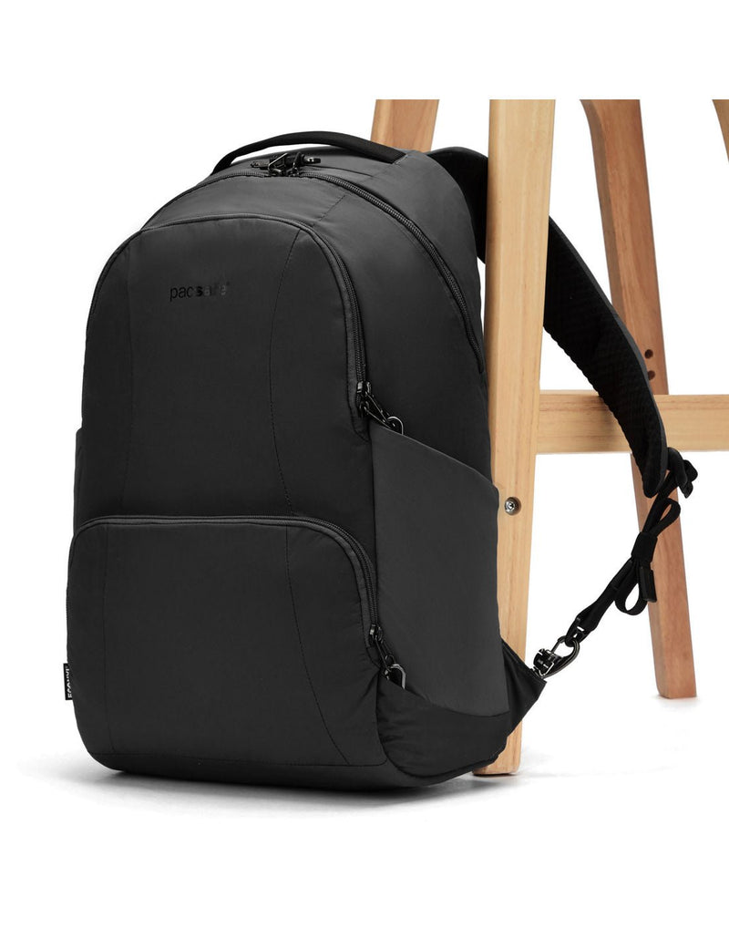 Pacsafe® LS450 Anti-Theft 25L Backpack, black, attached to a chair leg with a lockable backpack shoulder strap