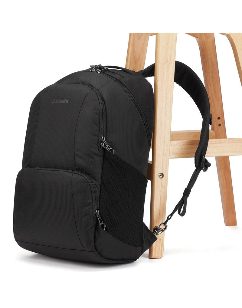 Pacsafe Metrosafe LS450 Anti-Theft 25L Backpack, black, with one strap secured to a chair leg
