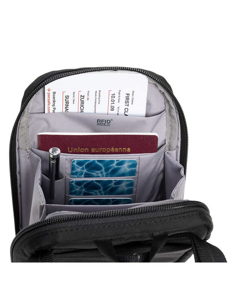 Pacsafe® RFIDsafe™ RFID Blocking Tech Crossbody, black, interior view of RFID slip pocket with boarding pass and passport inside, and pen in pen loop and cards in three card slots