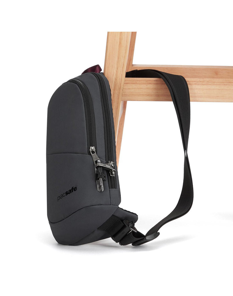 Pacsafe® Vibe 150 Anti-theft Sling Pack, slate, attached to chair leg with lockable sling strap