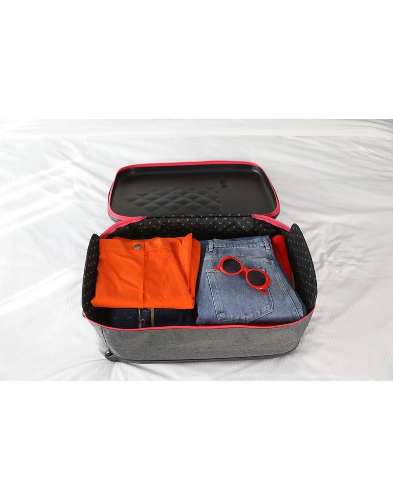 Rollink Flex Earth 20" Carry-On open and packed with clothes on a bed