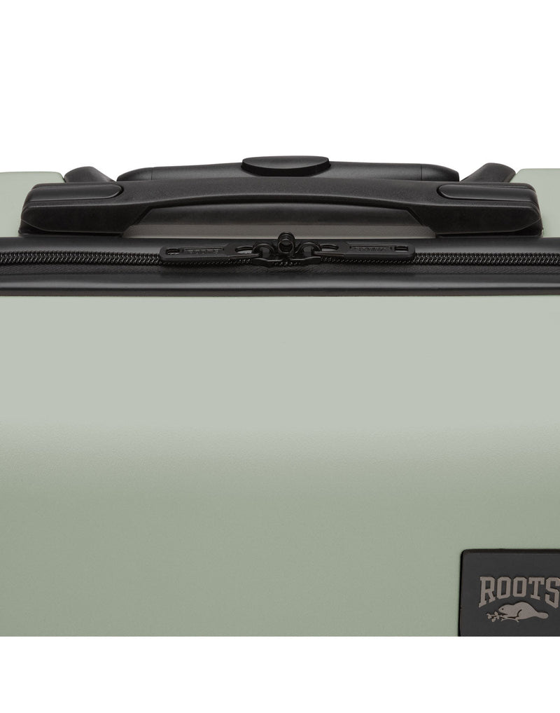 Close up of black top grab handle on seagrass Roots Panorama 19" Hardside Spinner Carry-on
