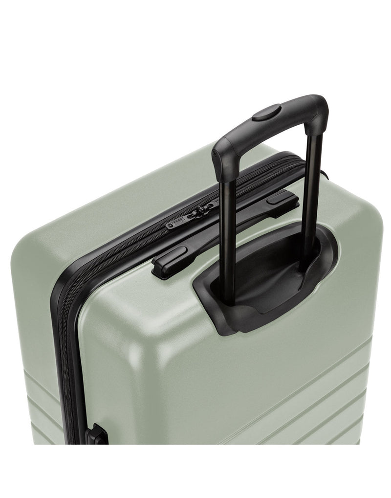 Roots Panorama 28" Hardside Expandable Spinner in seagrass, pale green colour, top back angled view of black telescopic handle extended