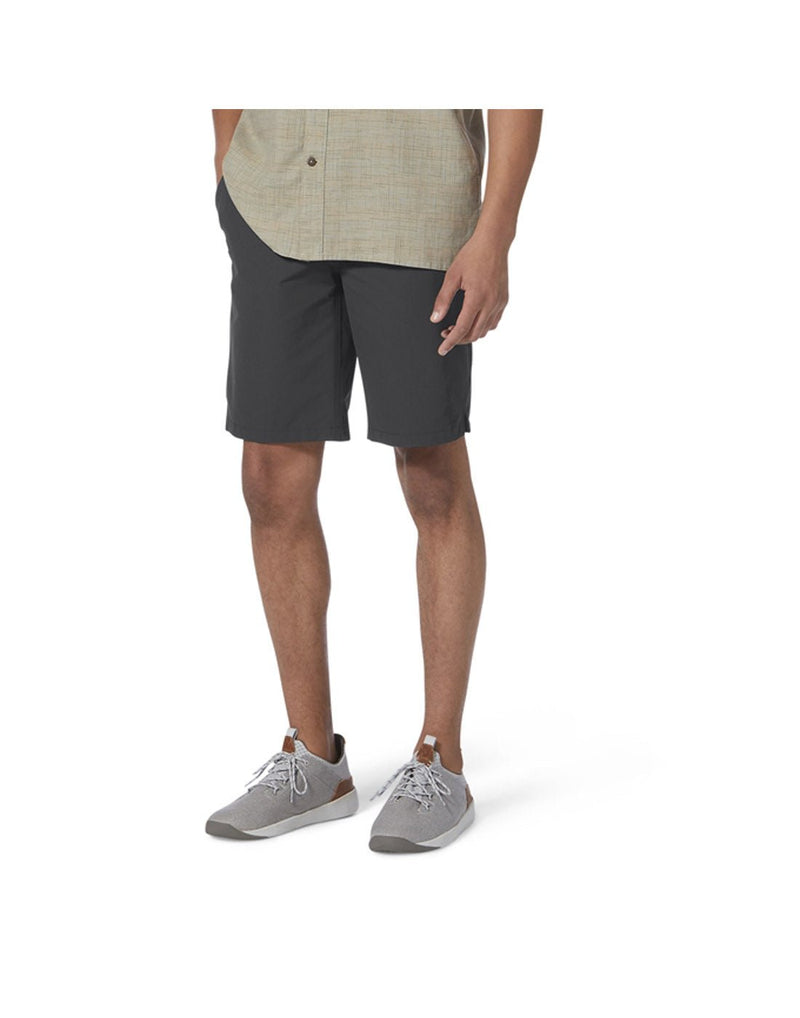 Bottom half of man wearing Royal Robbins Men's Backcountry Pro Multi Short in charcoal grey with beige button shirt and running shoes