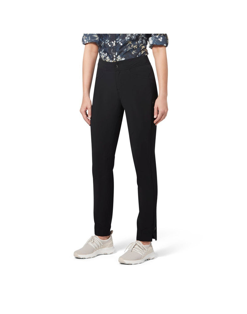 Front view of a woman's torso wearing Royal Robbins Women's Alpine Mountain Pro Pant in jet black, blue floral print shirt tucked in and cream colour runners.