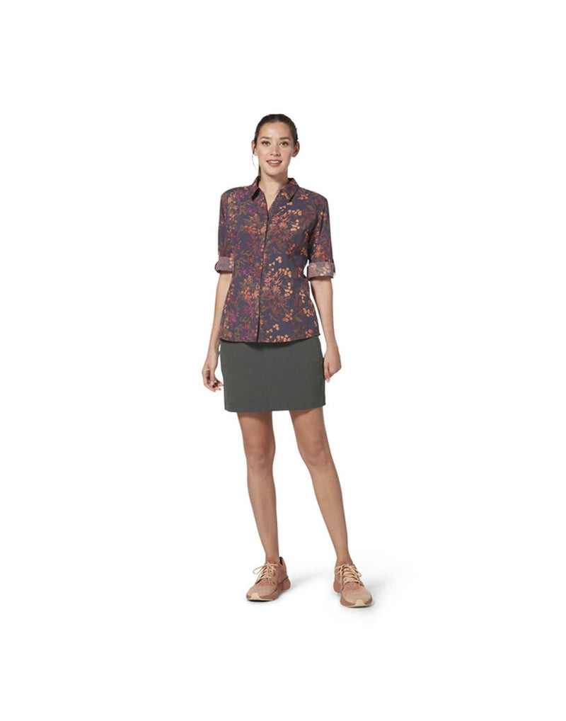 Woman wearing Royal Robbins Women's Alpine Mountain Pro Skort in asphalt grey colour with floral button shirt and beige running shoes