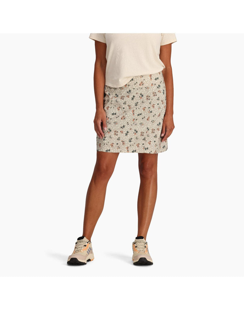 Bottom half of woman wearing Royal Robbins Women's Discovery III Printed Skort in light khaki colour with off-white t-shirt and matching running shoes