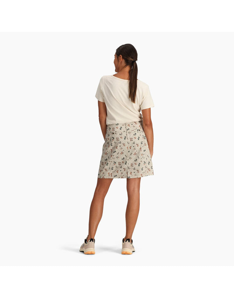 Back view of woman wearing Royal Robbins Women's Discovery III Printed Skort in light khaki colour with an off-white t-shirt tucked in and matching running shoes