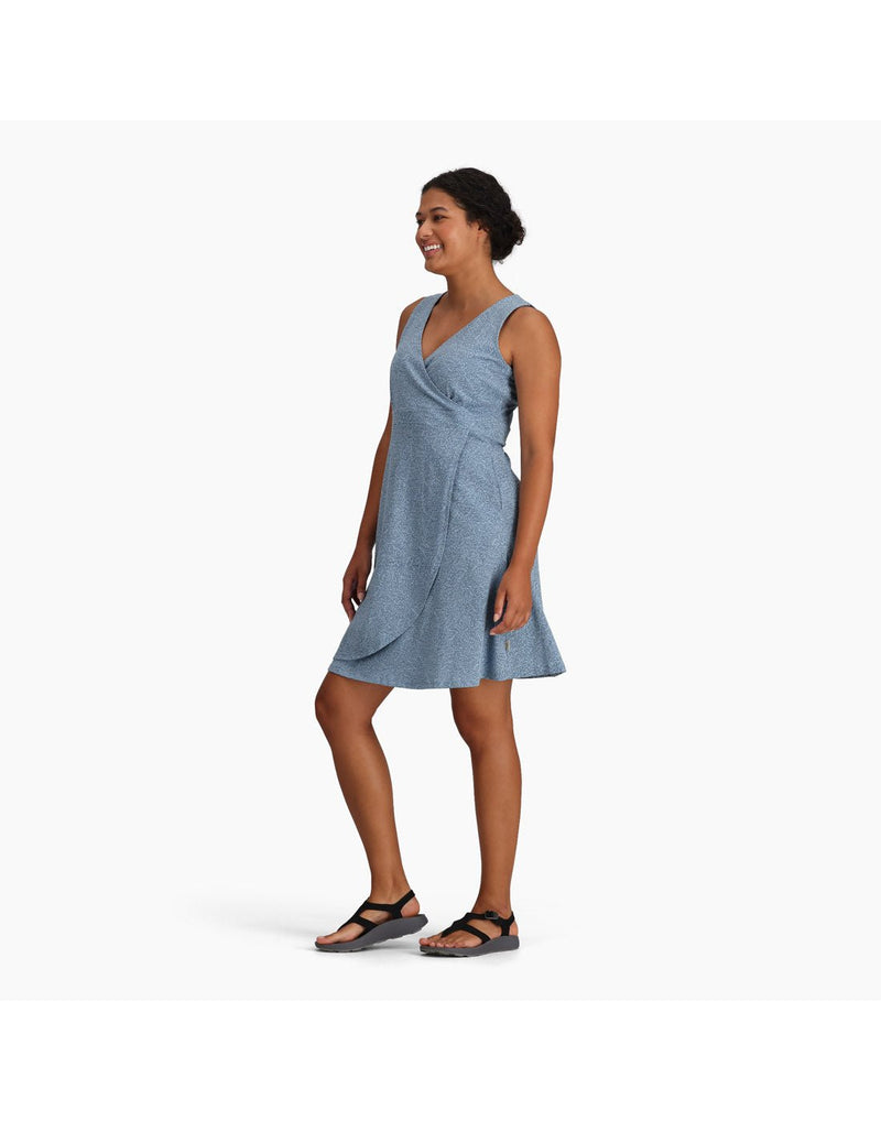 Woman wearing Royal Robbins Women's Featherweight Knit Dress in sea niserne print, blue colour with black sandals, side angled view