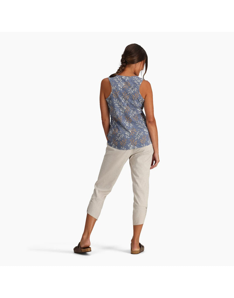 Woman wearing Royal Robbins Women's Featherweight Tank in chicory blue usla print, and khaki pants and sandals, back view with one hand in pocket