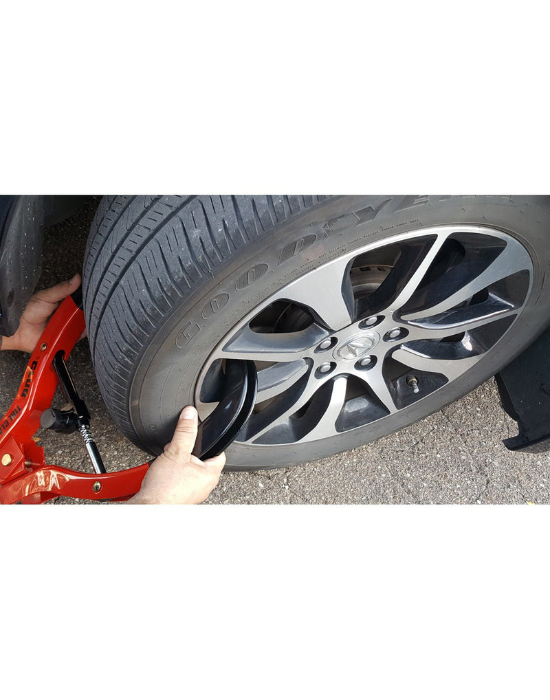 Lifestyle image of person clamping the Club Tire Claw XL on a vehicle tire