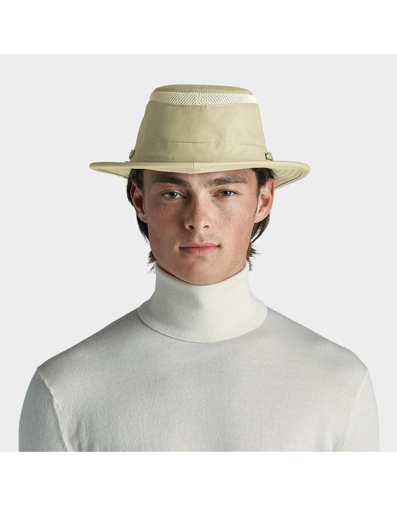 Portrait image of a man wearing white turtleneck sweater and khol colour Tilley LTM5 AIRFLO® Hat, looking straight at camera