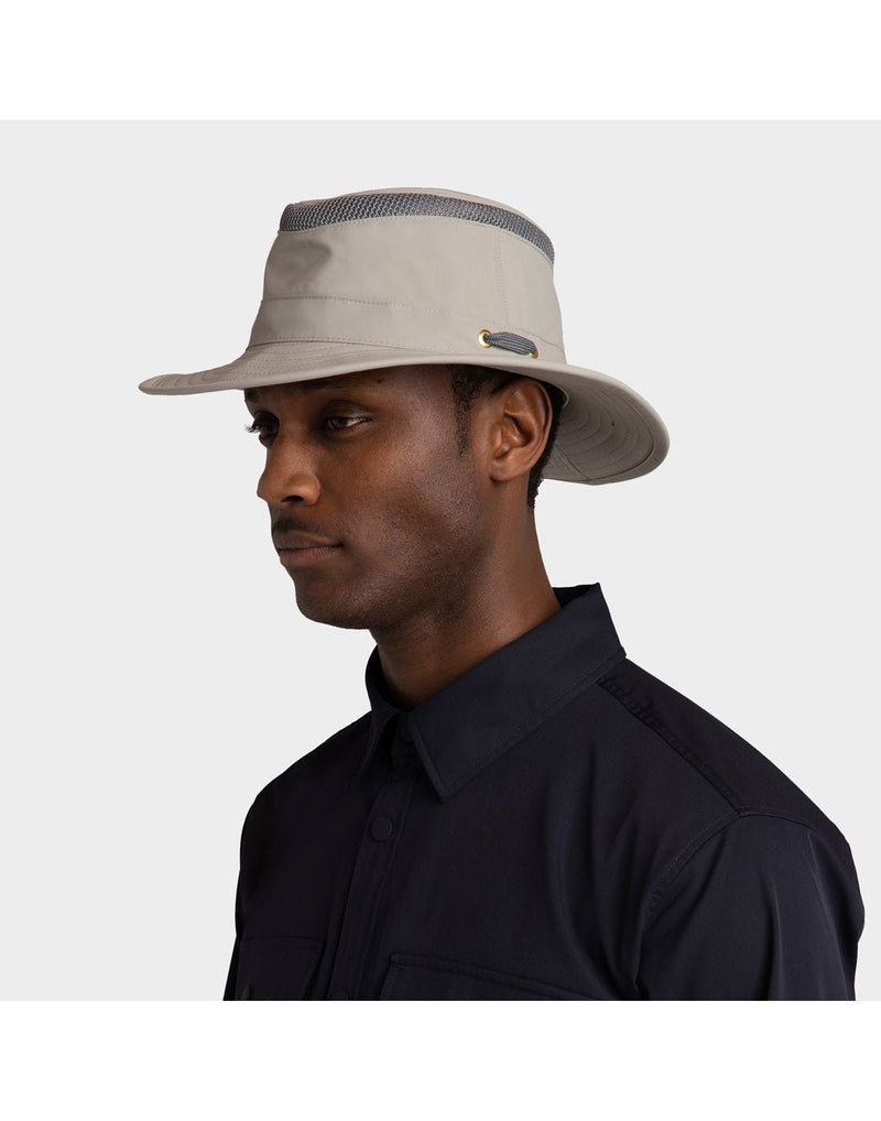 Portrait image of a man wearing navy blue button shirt and Rock Face light grey colour Tilley LTM5 AIRFLO® Hat, side angled view