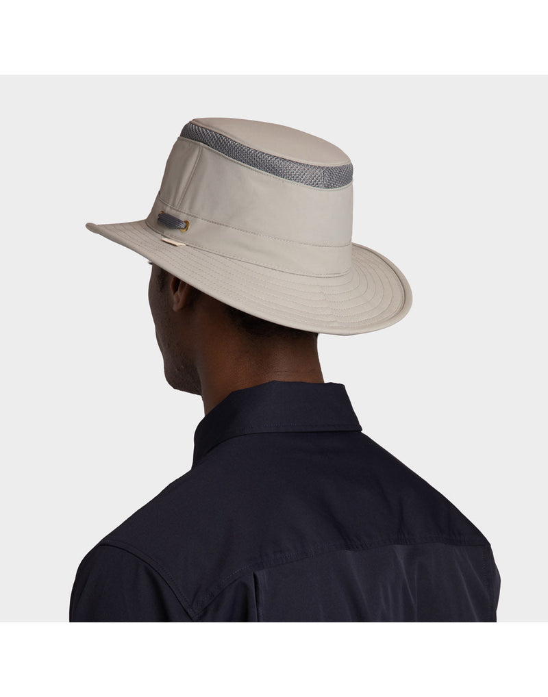 Portrait image of a man wearing navy blue button shirt and Rock Face light grey colour Tilley LTM5 AIRFLO® Hat, back angled view