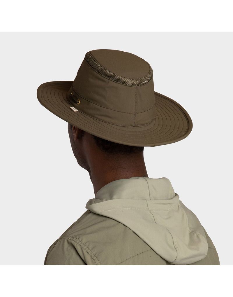 Portrait image of a man wearing khaki zip up shirt and the olive Tilley LTM6 Airflo Hat, back angled view