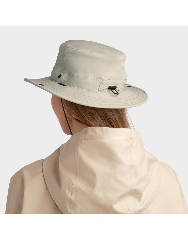 Woman wearing beige jacket and Tilley Rain Hat in stone, back angled view